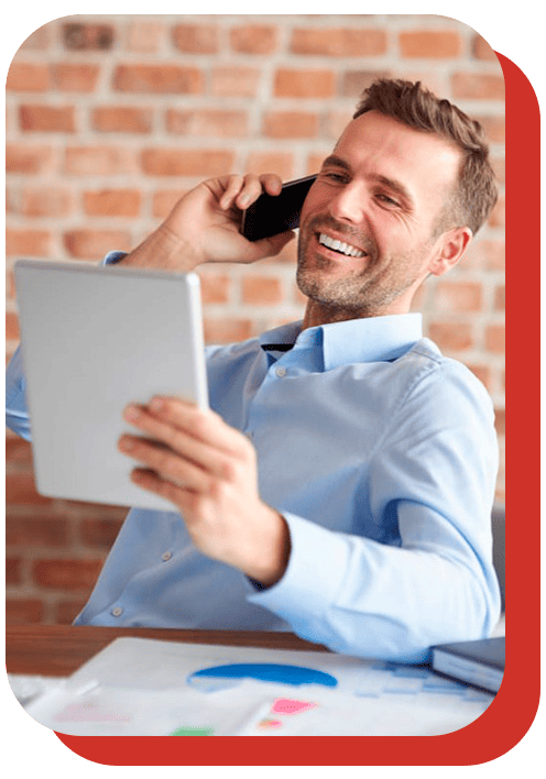 Síndico sorrindo ao telefone e usando tablet — soluções completas para gestão do condomínio.